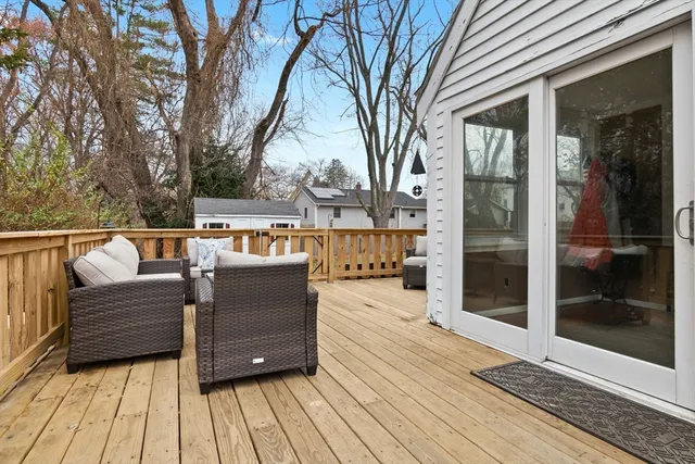 a view of a balcony with wooden floor and outdoor seating