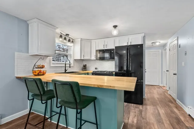 a kitchen with stainless steel appliances granite countertop a stove a sink a refrigerator and a microwave