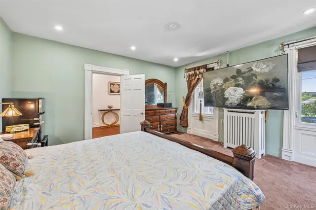 a bedroom with a bed and a flat tv screen on the dresser