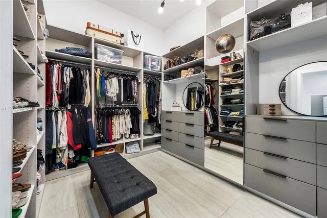 a view of walk in closet with clothes and shoes