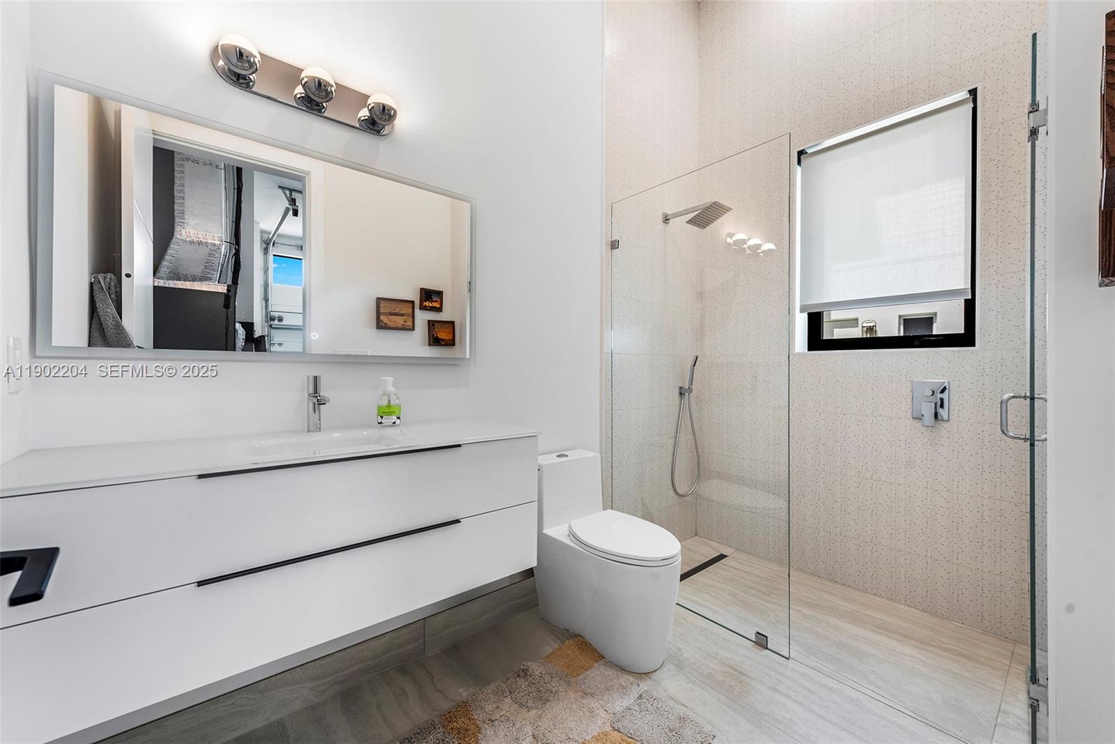 3701 Northeast 26th Avenue, Unit 1 Lighthouse Point, FL 33064 - Photo 46 of 46 a bathroom with a toilet sink and mirror