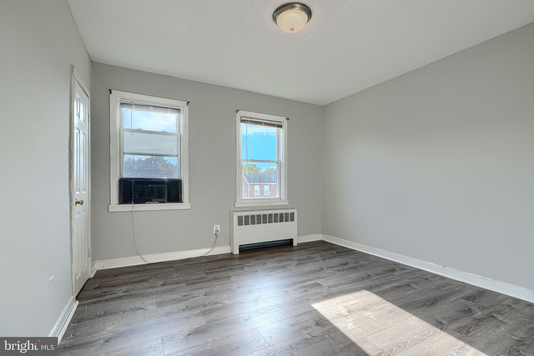 1236 Primrose Avenue Rosedale, MD 21237 - Photo 17 of 39 an empty room with wooden floor and windows