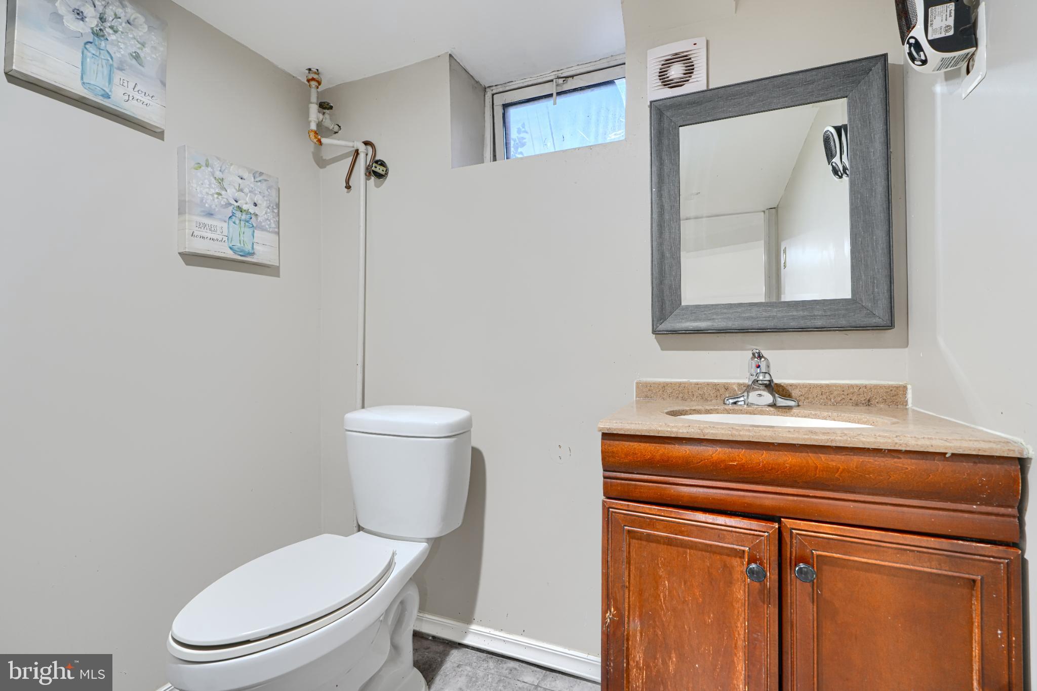 1236 Primrose Avenue Rosedale, MD 21237 - Photo 29 of 39 a bathroom with a toilet a sink and mirror