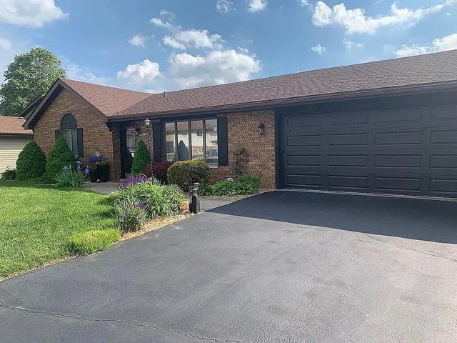 a view of a house with a yard and potted plants