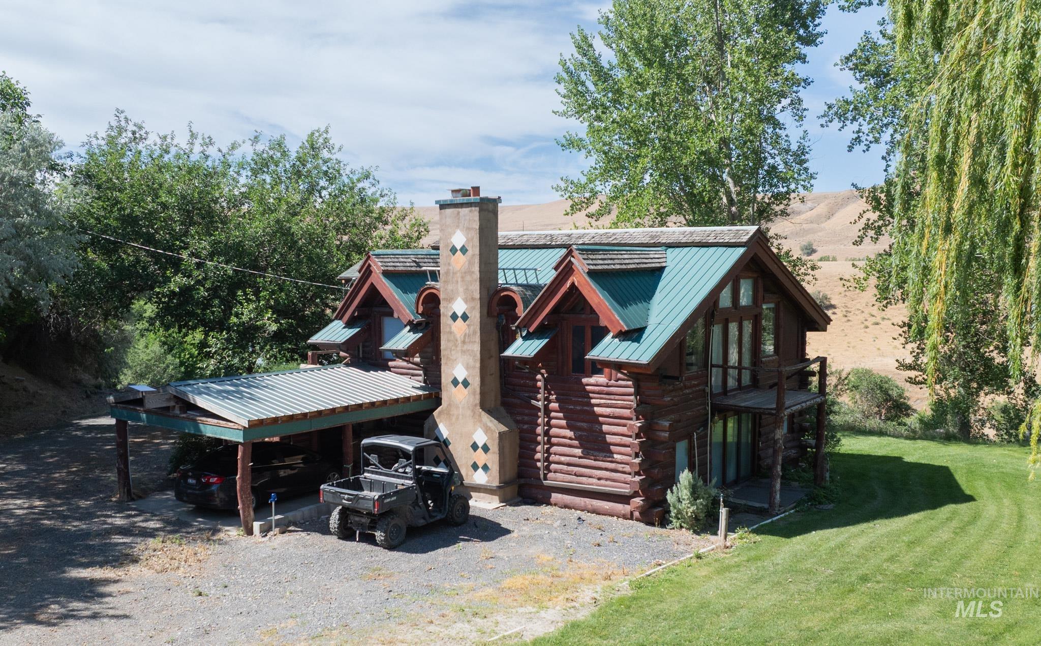 863 Pottery Road Bliss, ID 83314 - Photo 2 of 45 Log cabin exterior with a teal metal roof and decorative chimney