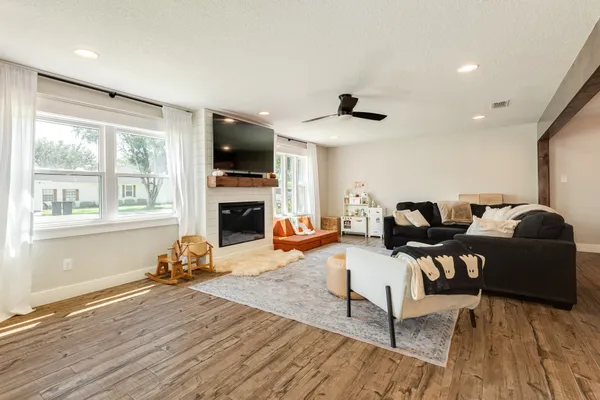 a living room with furniture a flat screen tv and a fireplace