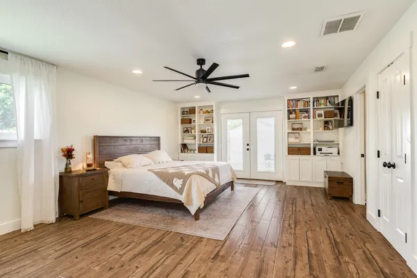 a bedroom with a large bed a window and closet