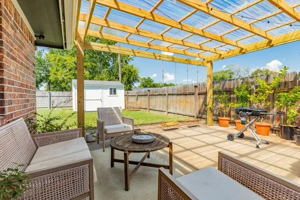 a view of a patio with a table and chairs and potted plants