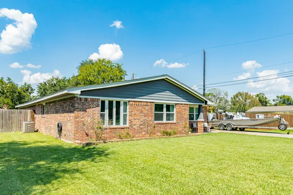 a front view of house with yard and trees in the background