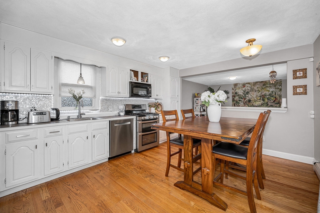 44 Mill Street Revere, MA 02151 - Photo 12 of 36 a kitchen with a table chairs microwave and cabinets