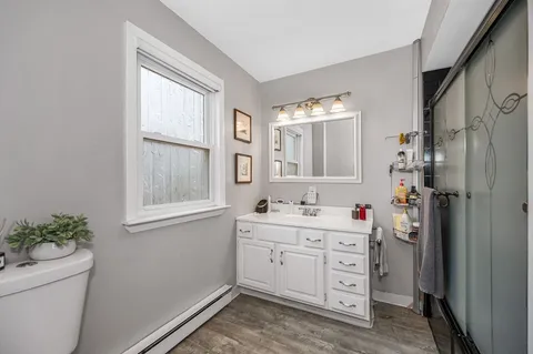 a room with a window a sink and a mirror