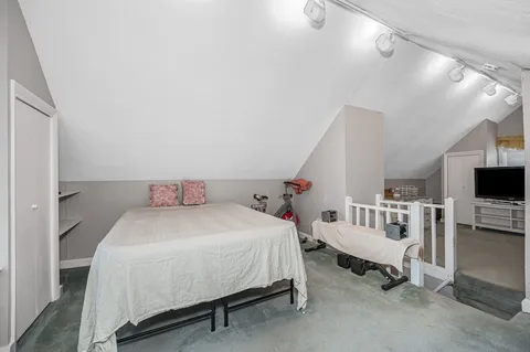 a bedroom with a bed a flat screen tv and dresser