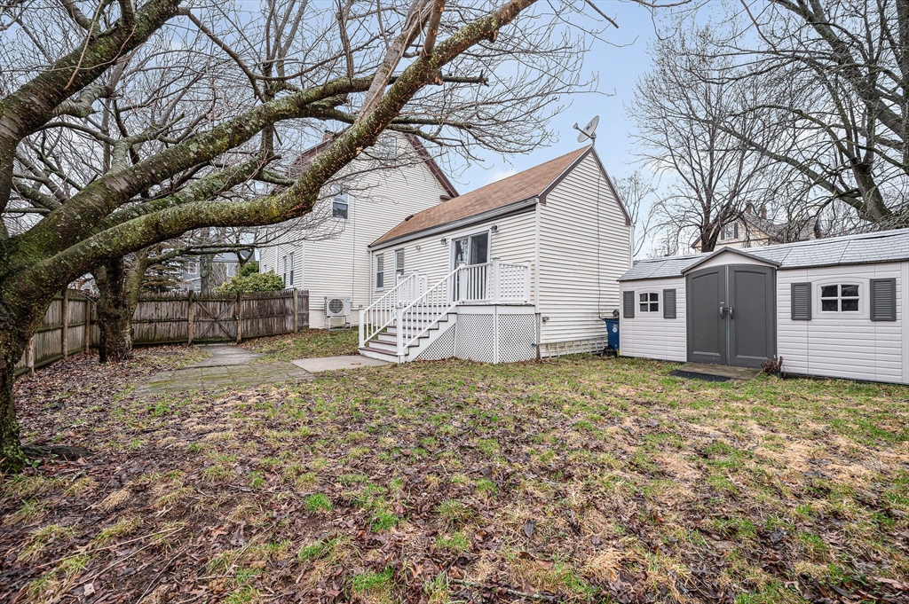 44 Mill Street Revere, MA 02151 - Photo 31 of 36 a backyard of a house with large trees and barbeque oven