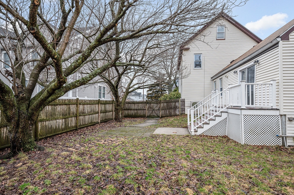 44 Mill Street Revere, MA 02151 - Photo 32 of 36 a view of backyard with a large tree and wooden fence
