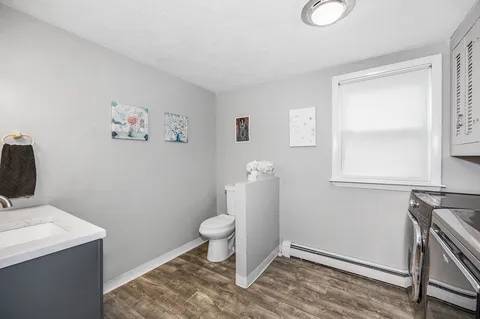 a bathroom with a toilet a sink and a window