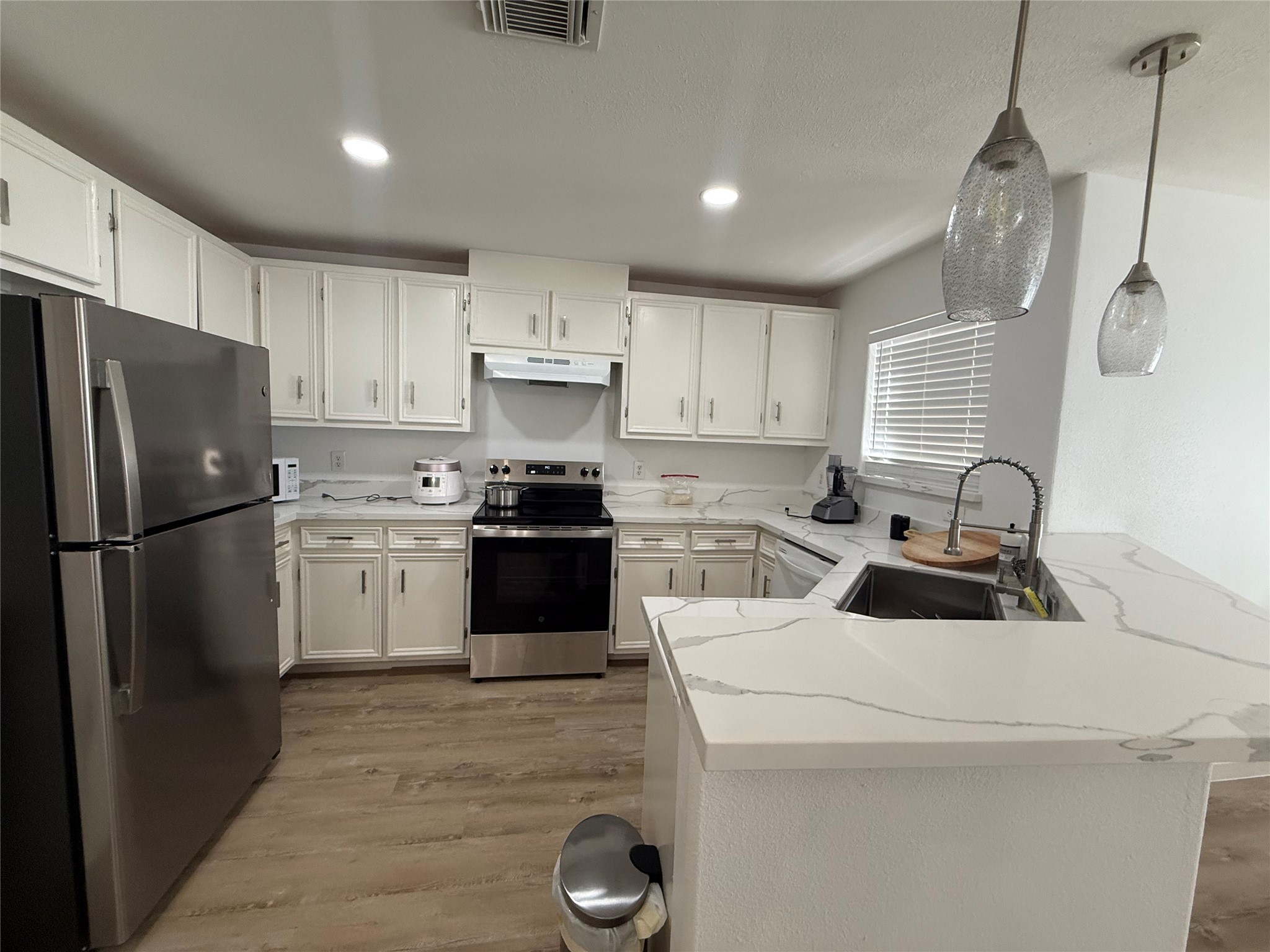3114 Bolt Street Houston, TX 77051 - Photo 29 of 32 a kitchen with a sink a stove a refrigerator and cabinets