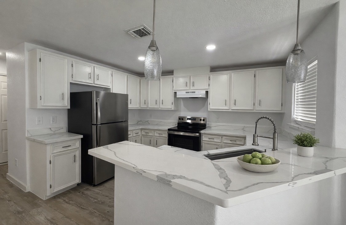 3114 Bolt Street Houston, TX 77051 - Photo 3 of 32 a kitchen with stainless steel appliances a sink a stove a refrigerator a center island and cabinets