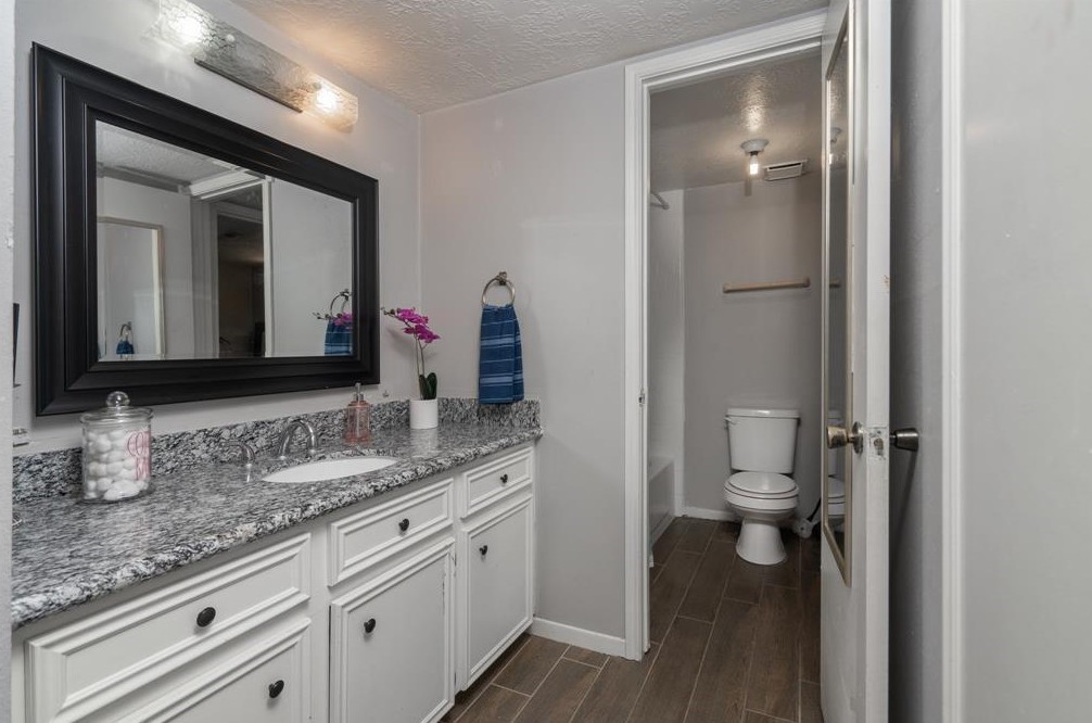 11500 Meadow Lane, Unit 4 Houston, TX 77477 - Photo 12 of 32 a bathroom with a granite countertop sink toilet and mirror