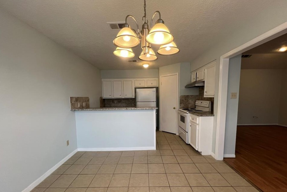 11500 Meadow Lane, Unit 4 Houston, TX 77477 - Photo 15 of 32 a kitchen with a stove cabinets and a refrigerator
