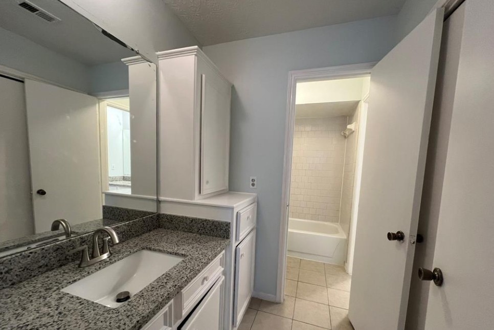 11500 Meadow Lane, Unit 4 Houston, TX 77477 - Photo 21 of 32 a bathroom with a granite countertop sink and a mirror