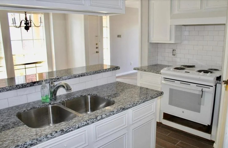 11500 Meadow Lane, Unit 4 Houston, TX 77477 - Photo 6 of 32 a kitchen with granite countertop a sink dishwasher a stove and a refrigerator with wooden cabinets