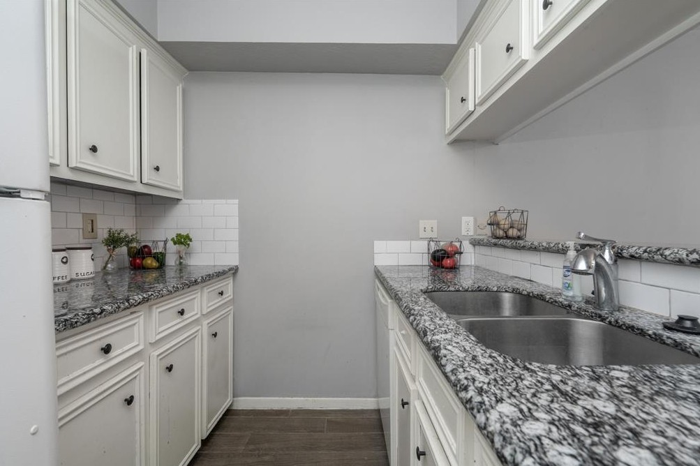 11500 Meadow Lane, Unit 4 Houston, TX 77477 - Photo 10 of 32 a kitchen with kitchen island granite countertop a sink a counter space and cabinets