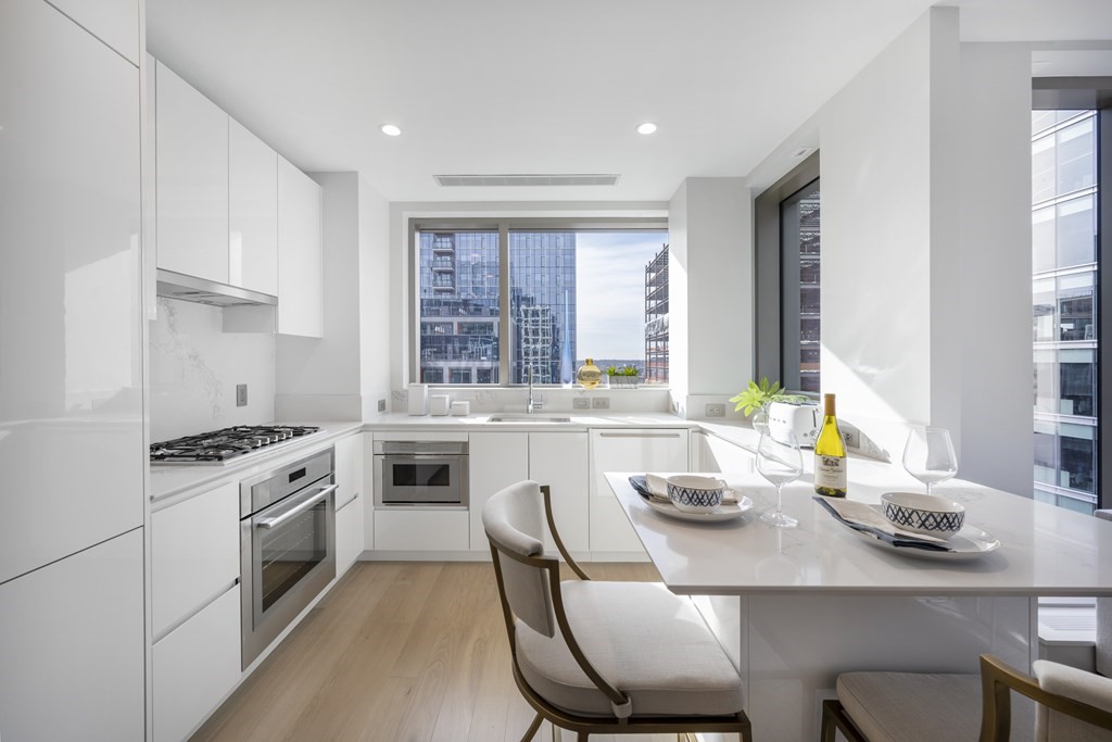 133 Seaport Boulevard, Unit 1603 Boston, MA 02210 - Photo 4 of 21 a kitchen with stainless steel appliances granite countertop a stove a sink a stove a table and chairs