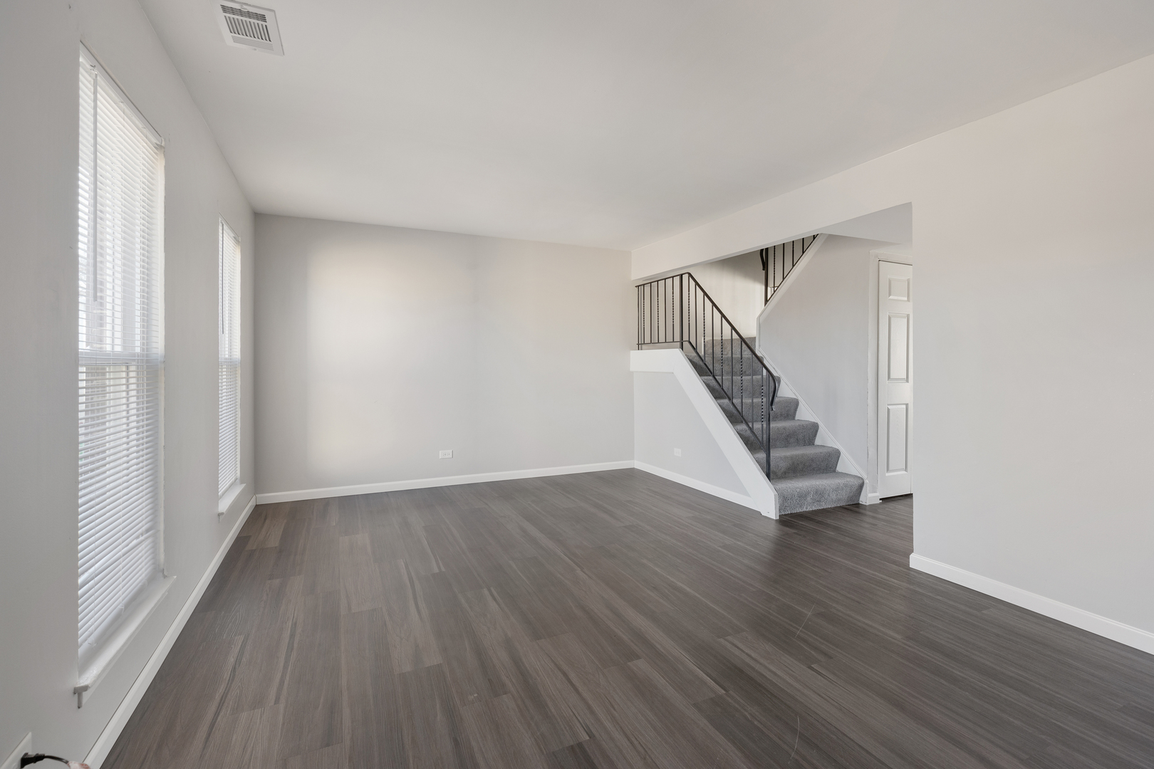318 Rodenburg Road Roselle, IL 60172 - Photo 2 of 14 an empty room with wooden floor and staircase