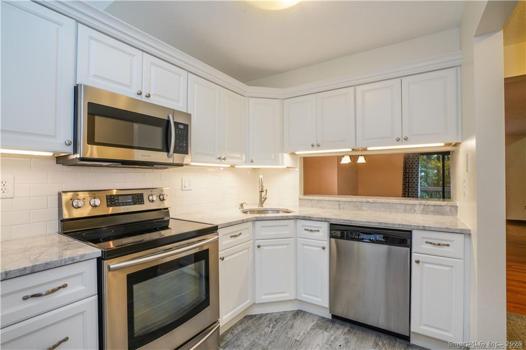 9 Red Stone Way, Unit 9 Farmington, CT 06032 - Photo 2 of 17 a kitchen with granite countertop white cabinets and stainless steel appliances