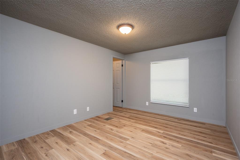 5027 Southwest 69 Street Gainesville, FL 32608 - Photo 15 of 21 a view of empty room with wooden floor and fan