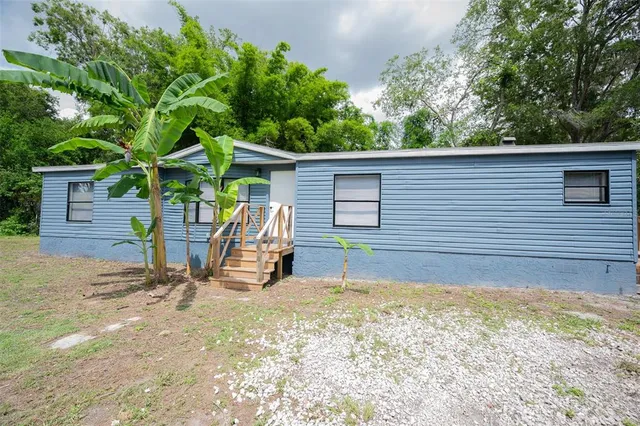 a view of a house with a backyard and chairs