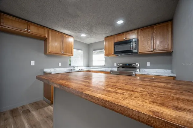 a kitchen with stainless steel appliances granite countertop a sink stove and microwave