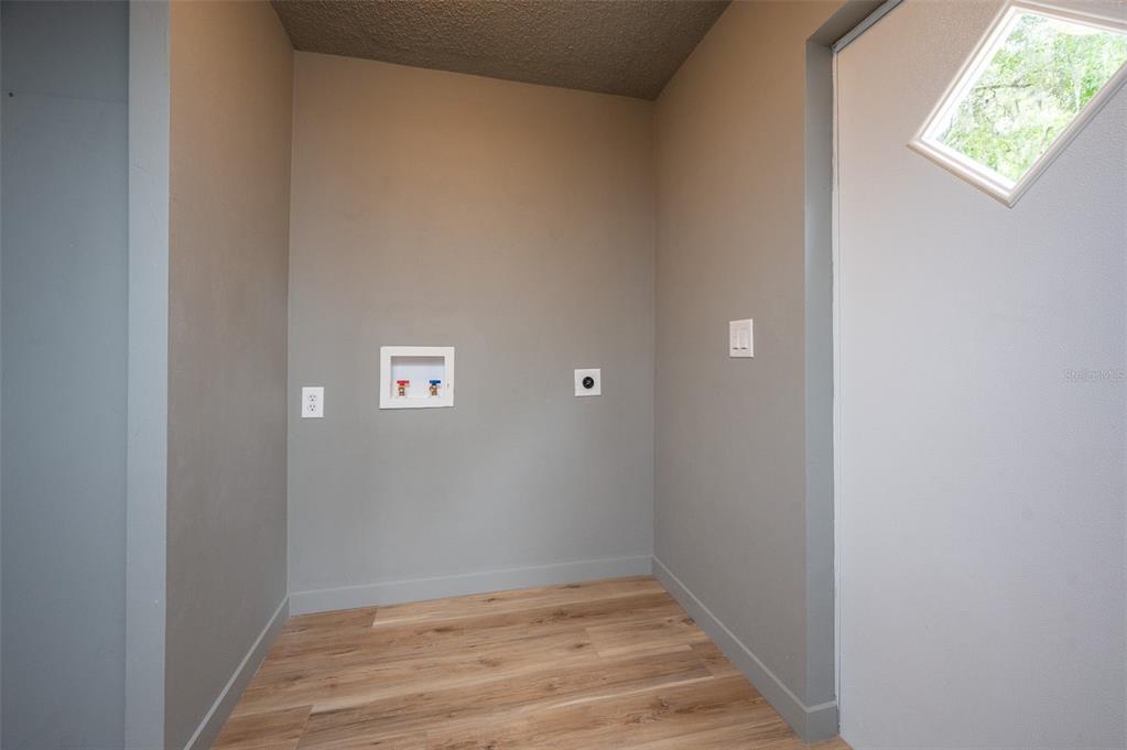5027 Southwest 69 Street Gainesville, FL 32608 - Photo 8 of 21 a view of an empty room with wooden floor and a window