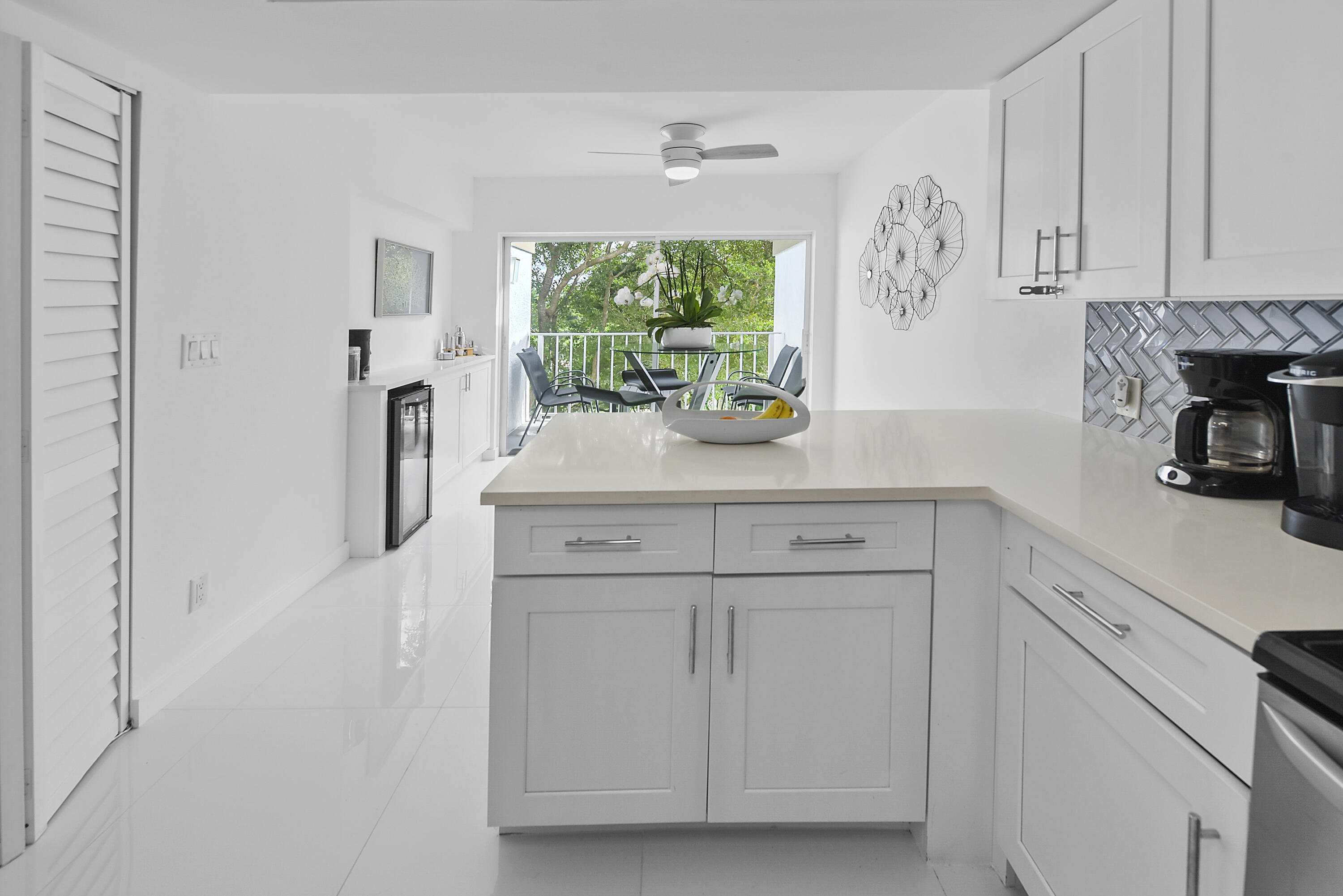 7369 Orangewood Lane, Unit 303 Boca Raton, FL 33433 - Photo 11 of 56 a kitchen with stainless steel appliances white cabinets and a window