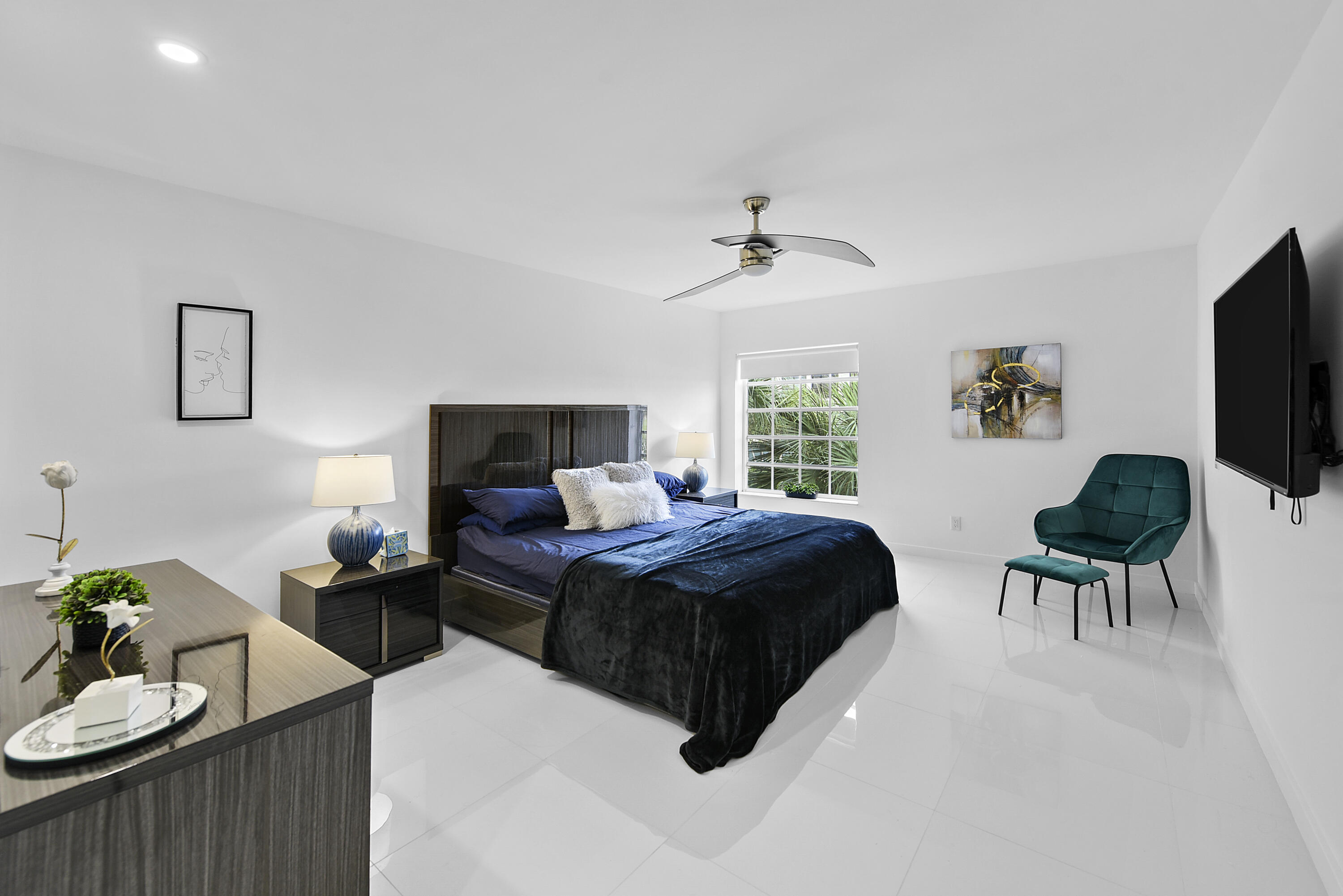 7369 Orangewood Lane, Unit 303 Boca Raton, FL 33433 - Photo 21 of 56 a bedroom with a bed a couch and a flat screen tv