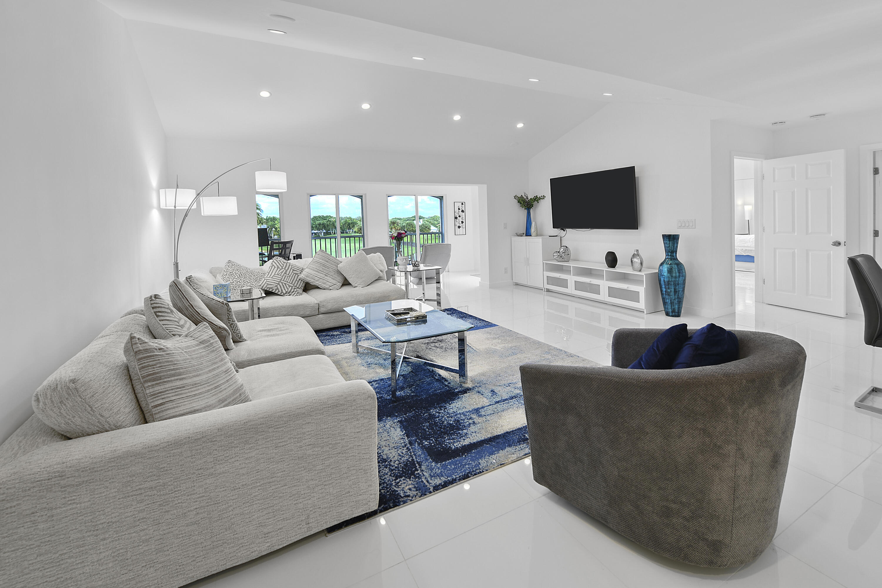 7369 Orangewood Lane, Unit 303 Boca Raton, FL 33433 - Photo 8 of 56 a living room with furniture and a flat screen tv