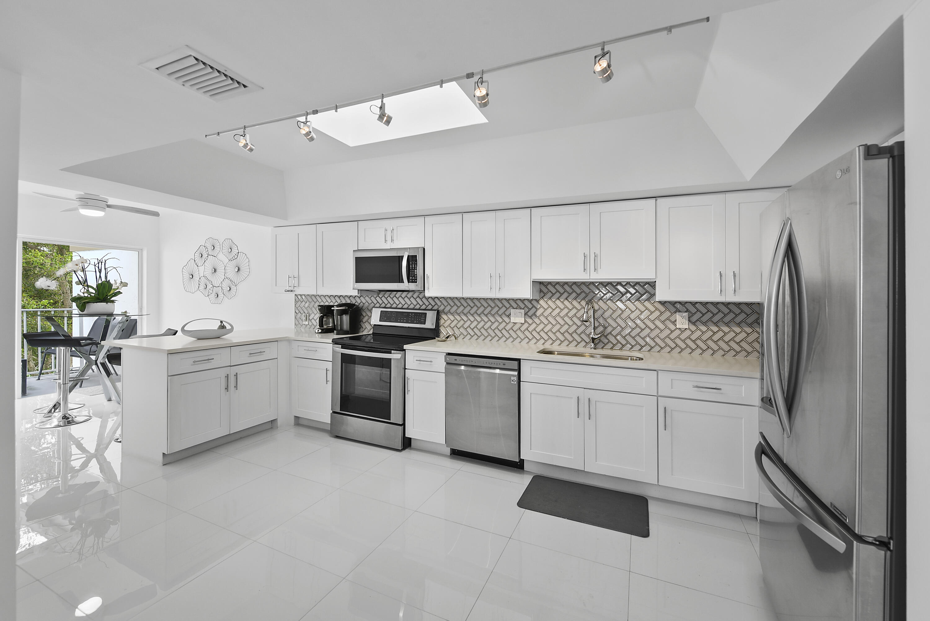 7369 Orangewood Lane, Unit 303 Boca Raton, FL 33433 - Photo 10 of 56 a kitchen with white cabinets and white appliances