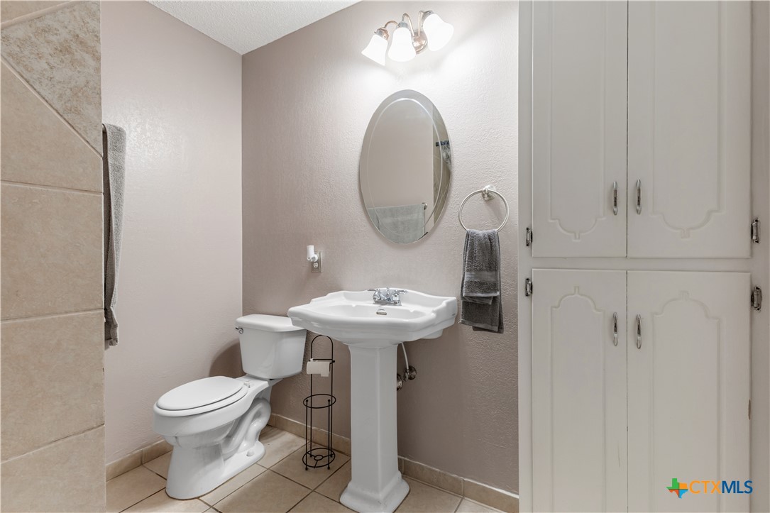 144 Jordan Loop Nolanville, TX 76559 - Photo 4 of 20 a bathroom with a toilet a sink and a mirror
