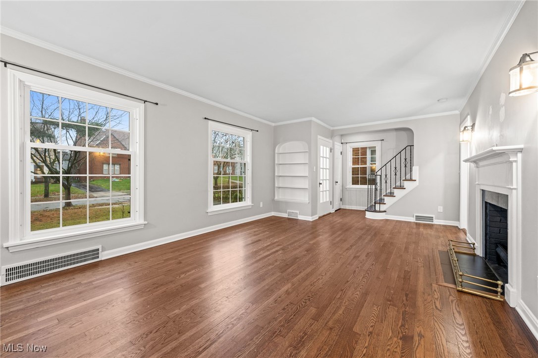 3662 Riedham Road Cleveland, OH 44120 - Photo 5 of 30 Unfurnished living room featuring hardwood / wood-style floors, built in shelves, and ornamental molding