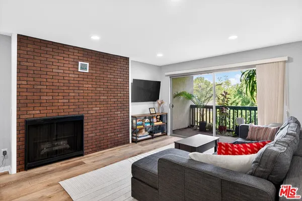 a living room with furniture large window and a fireplace