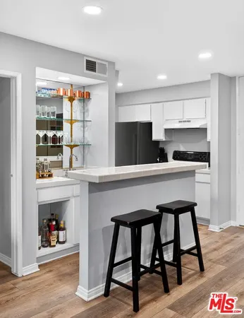 a kitchen with a table chairs refrigerator and window