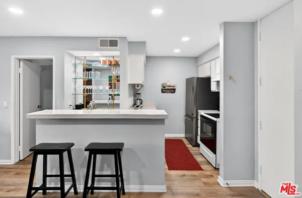 a kitchen with stainless steel appliances kitchen island granite countertop a refrigerator and a stove