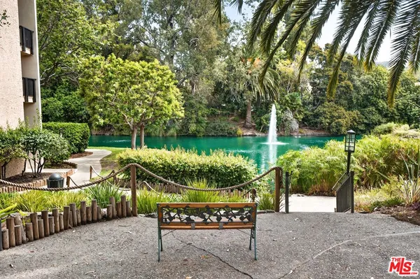 a view of a wooden chairs and table in the backyard