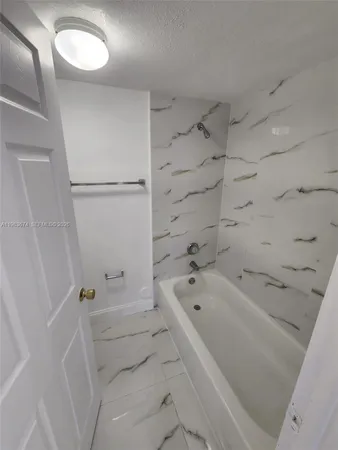 a kitchen with granite countertop a refrigerator a stove a microwave and a sink