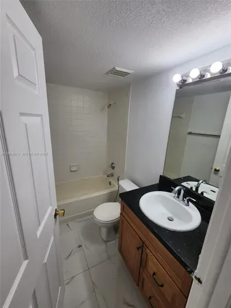 a bathroom with a sink a toilet a mirror and tub