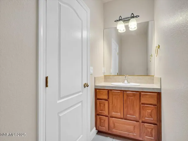 a spacious bathroom with a granite countertop sink a mirror and a shower