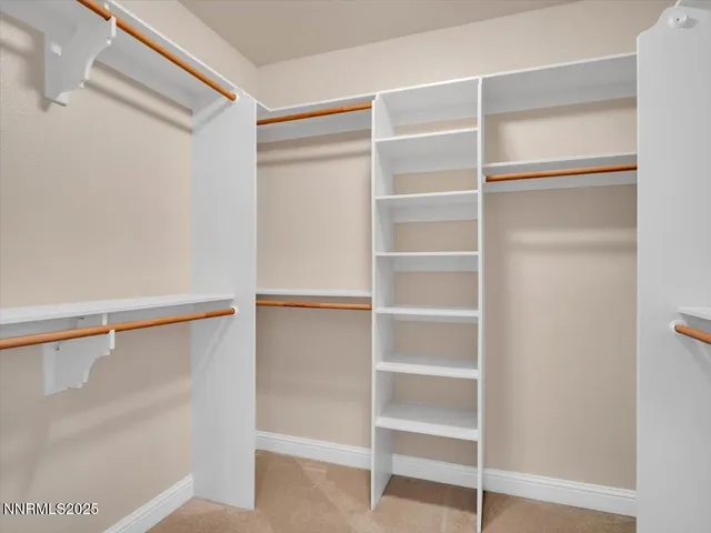 a view of a room with an empty space and a ceiling fan