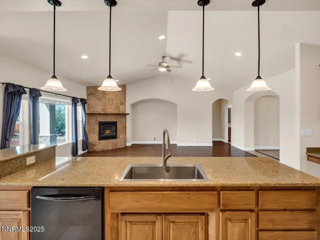 a kitchen with stainless steel appliances kitchen island granite countertop a stove a sink a refrigerator a center island and a cabinets