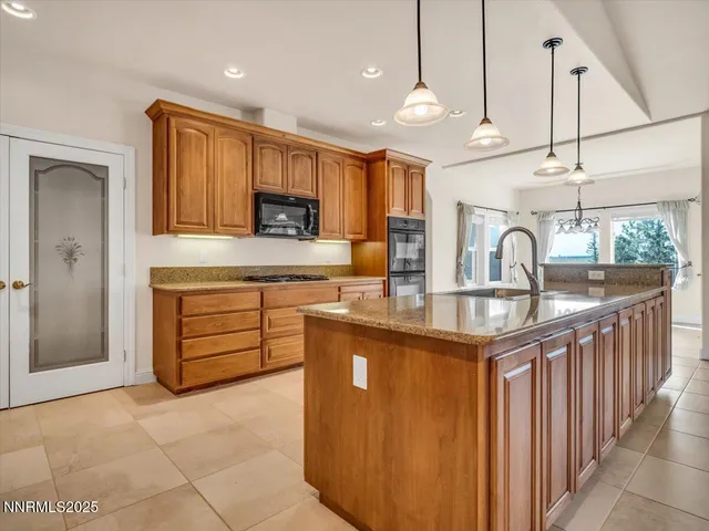 a kitchen with stainless steel appliances granite countertop a sink a stove and a wooden floors