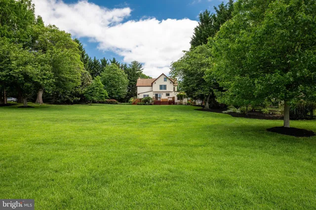 an aerial view of residential house with outdoor space and trees all around